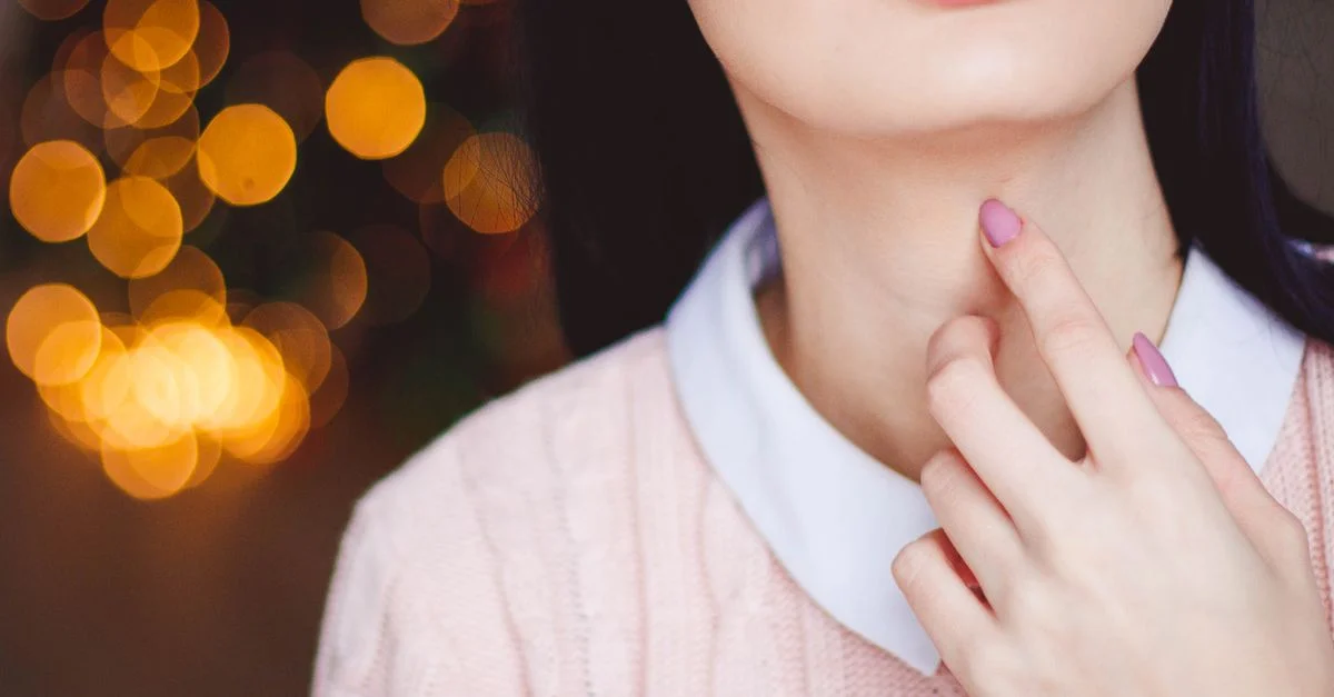 Primer plano del rostro y la mano de una mujer con un fondo bokeh, que muestra estilo y elegancia.